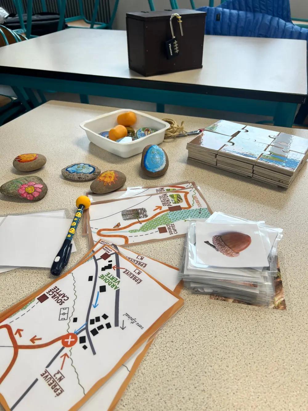 Cartes du parcours, galets peints, puzzle et boîte cadenassée d'un escape game
